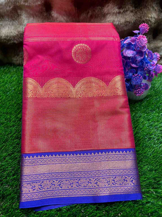 Pink saree with gold and blue border on a green grass background