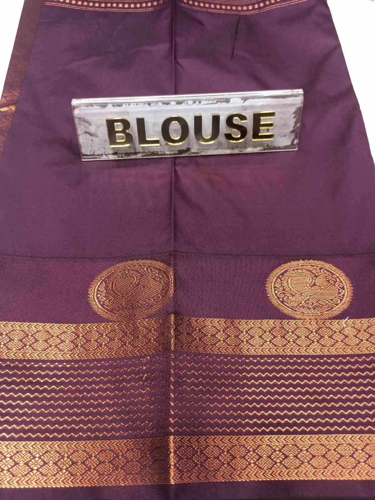 Purple blouse with gold patterns and a label on a white background