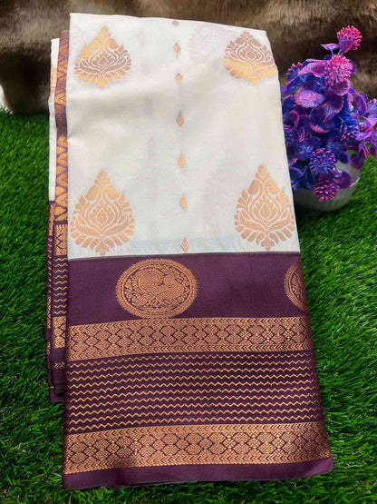 White and purple saree with gold patterns on a green grass background