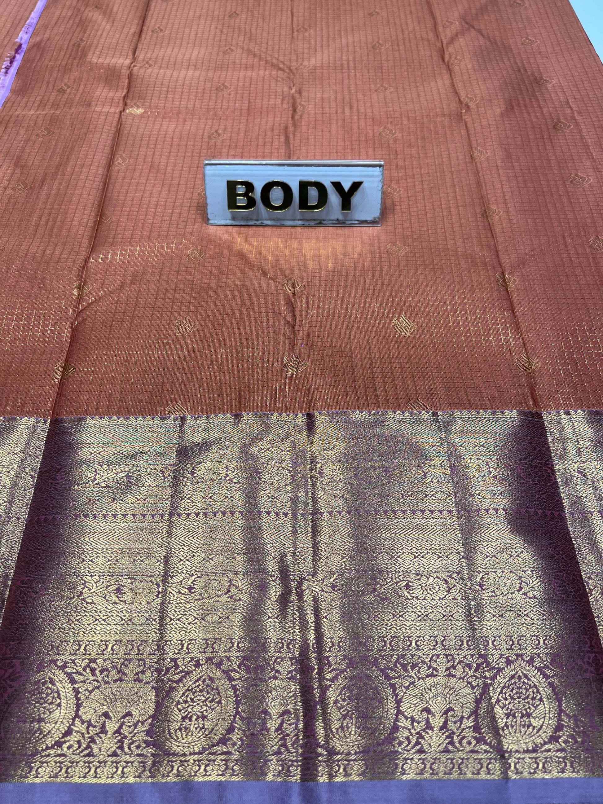 Two fabric swatches, one brown and one with intricate patterns, on a purple background.