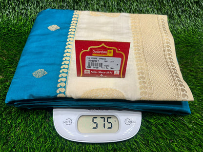 Blue and beige saree with a weight scale on a grass background