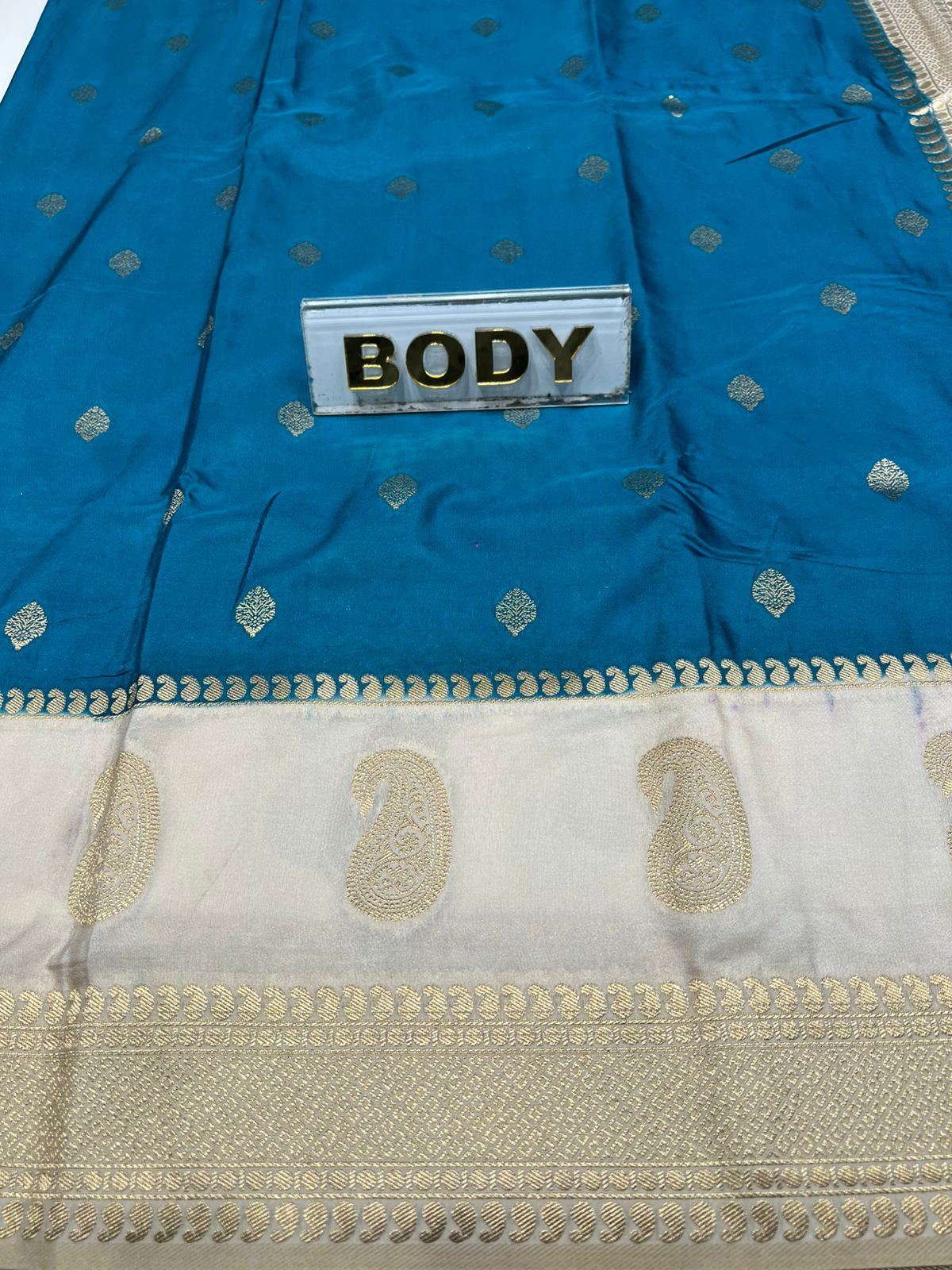 Blue saree with white border and 'BODY' label