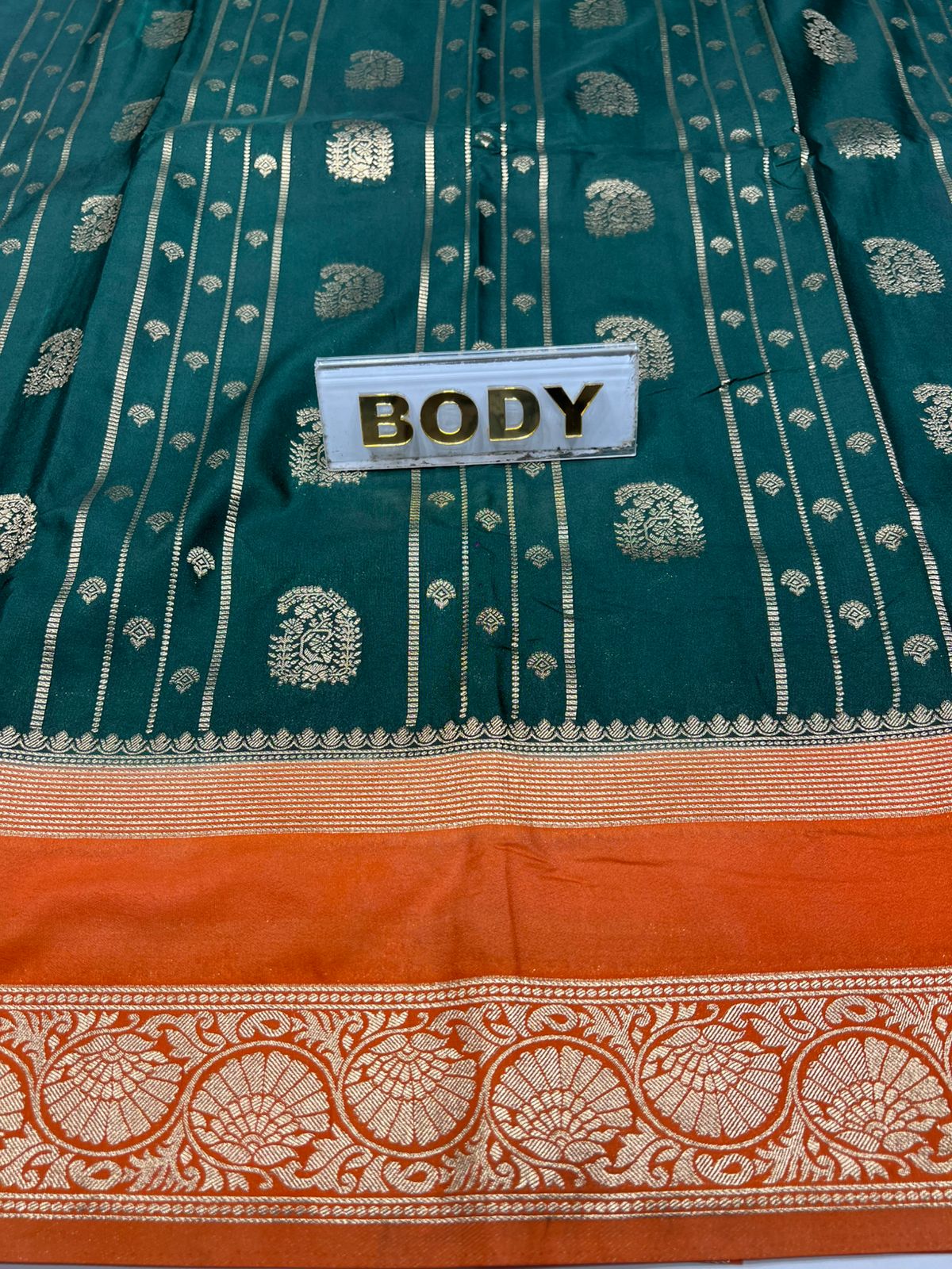Green and orange saree with decorative patterns and a label reading 'BODY'.