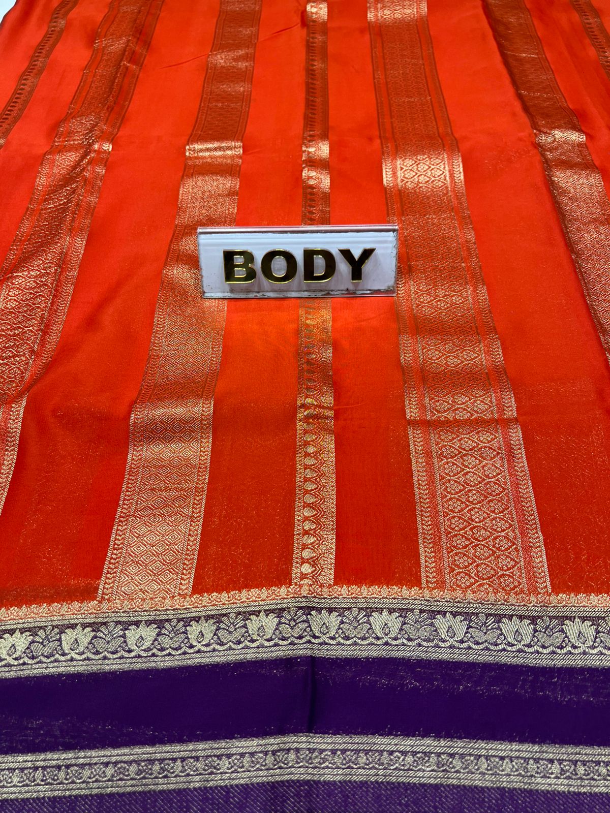Red and purple fabric with gold accents and a 'BODY' label.