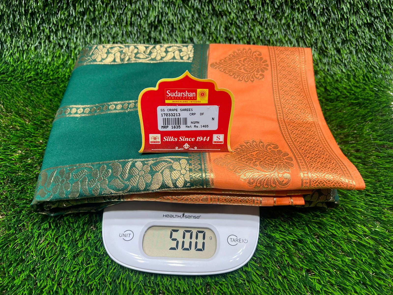 Green and orange book with a digital scale on grass