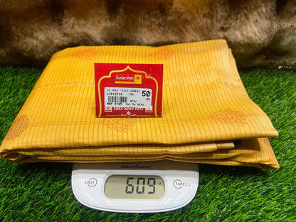 Yellow fabric with a label on a digital scale against a grass background