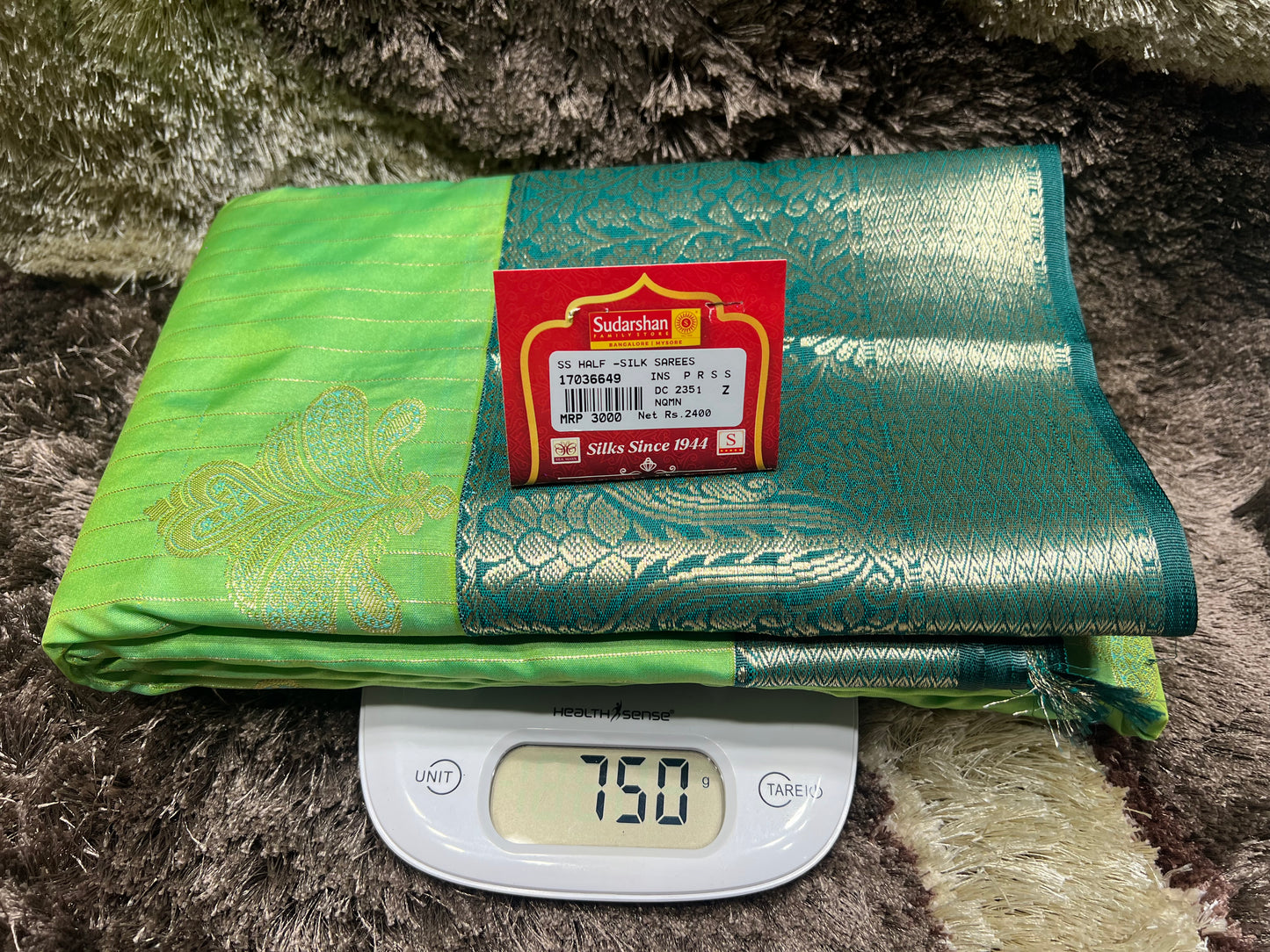 Green and gold fabric with a label on a digital scale