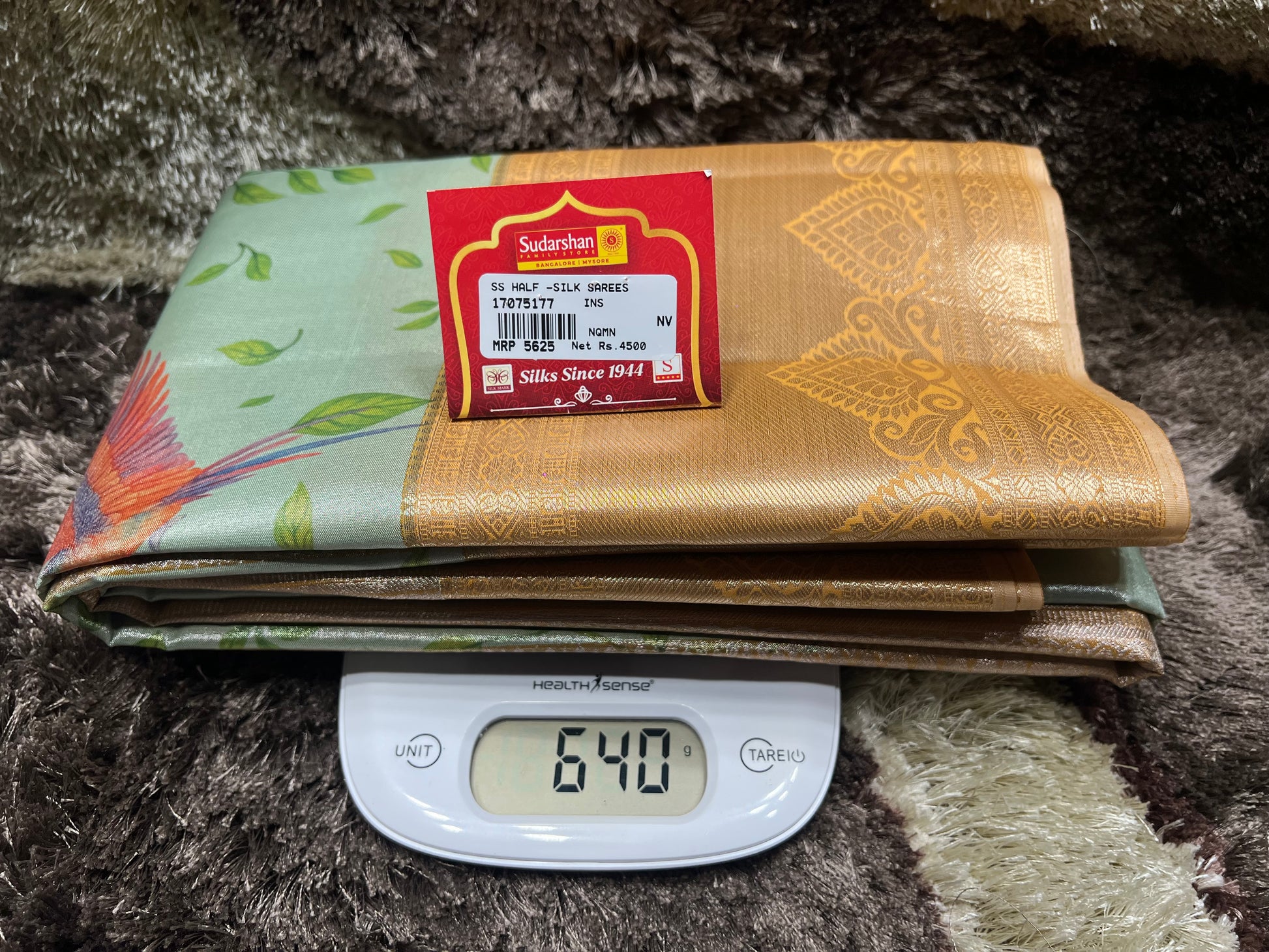 Folded fabric with a label on top of a digital scale showing weight