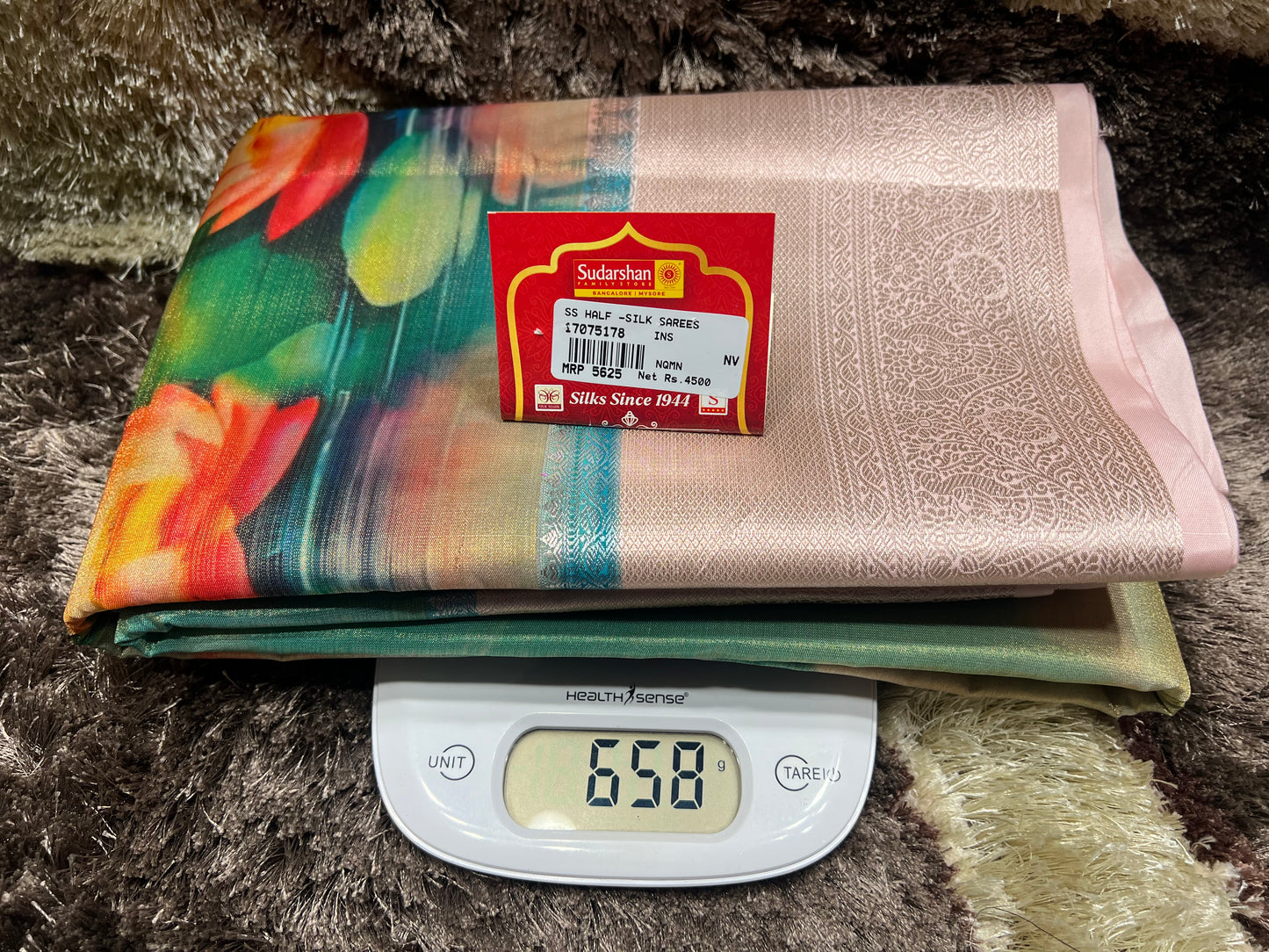 Two folded fabrics on a digital scale with a visible brand label.