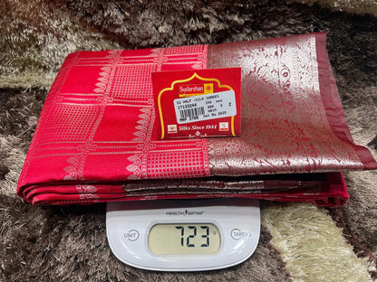 Red fabric with a brand label on a digital scale against a textured brown background