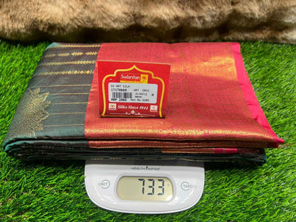 Red and black saree with a label on a digital scale against a grass background