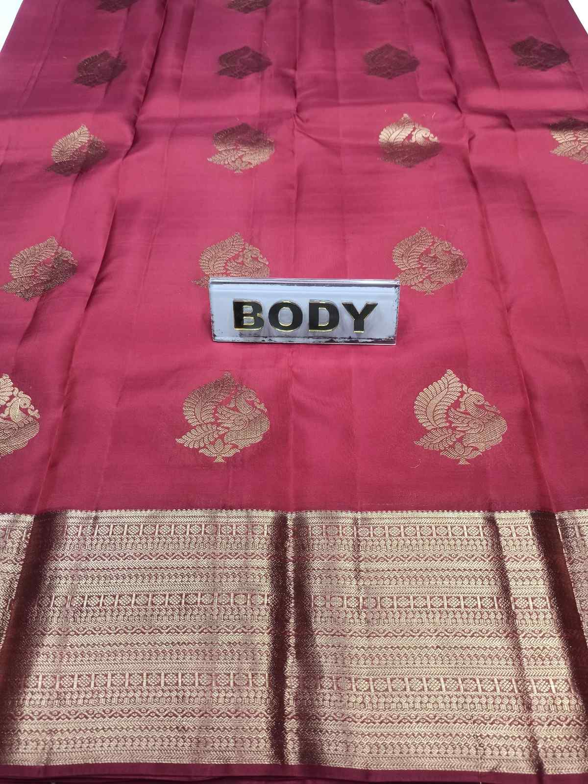 Red saree with gold patterns and a 'BODY' label on a white background