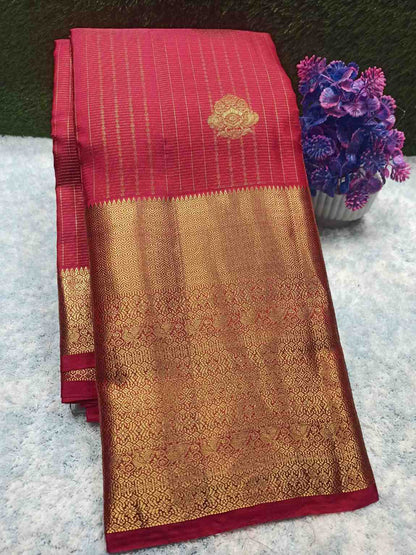 Red and gold saree with floral decoration on a textured surface