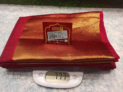 Red and gold fabric with a label on a digital scale