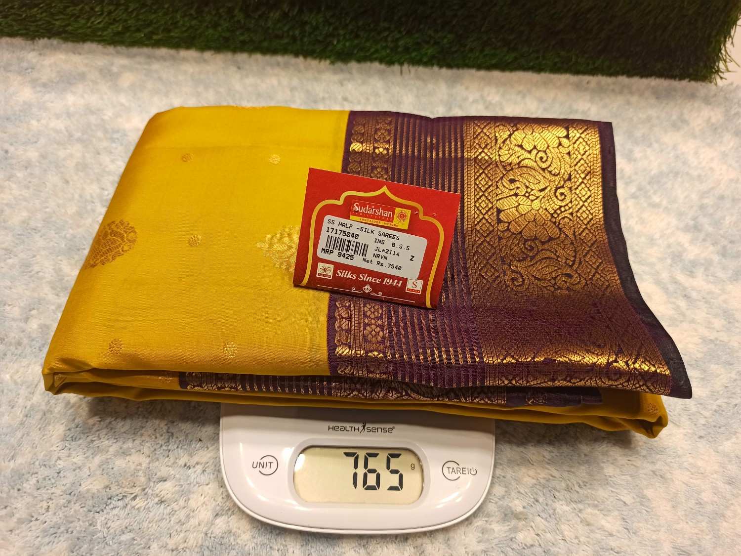 Yellow and purple fabric with a brand label on a digital scale