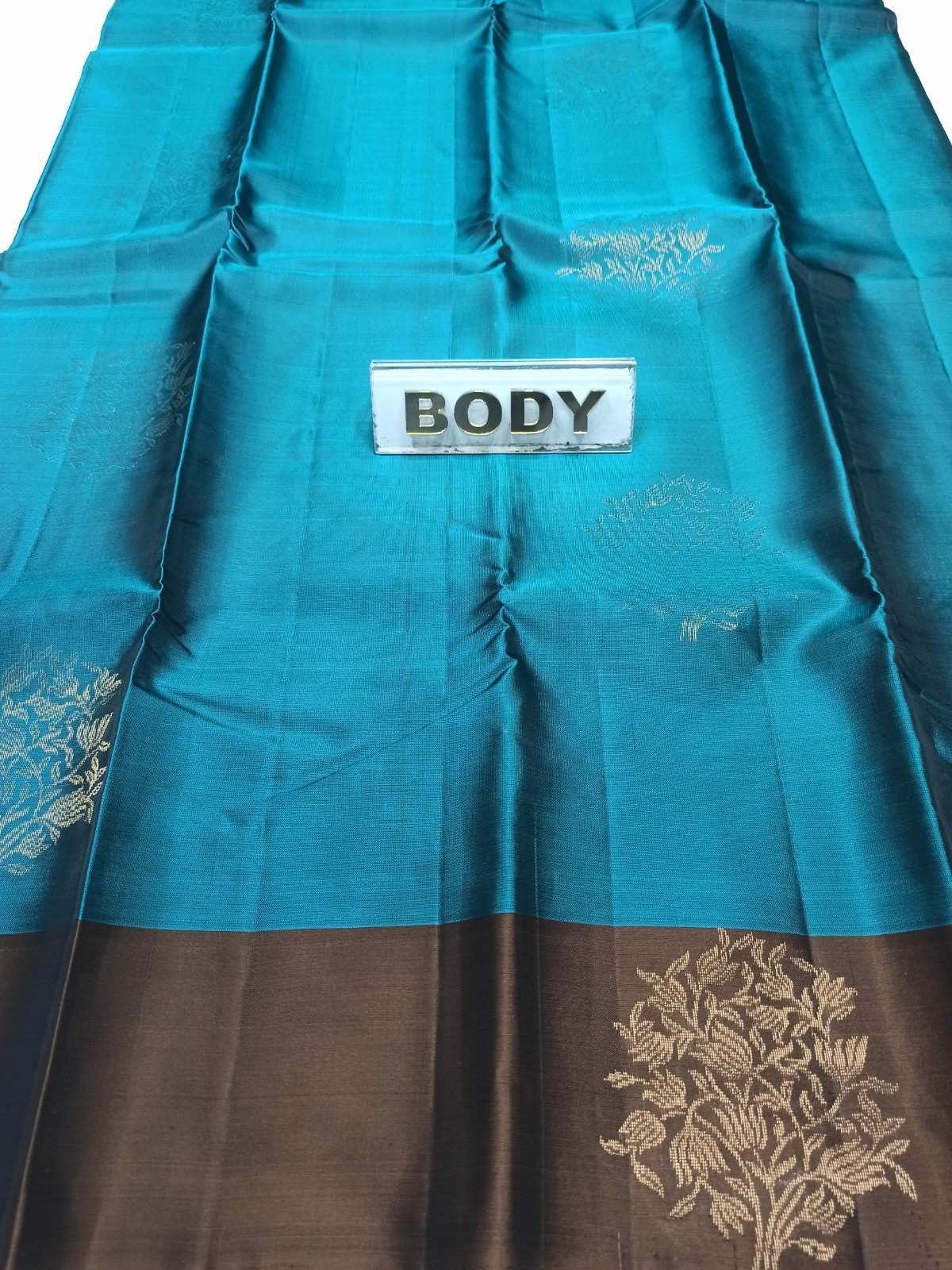 Teal fabric with floral patterns and a label labeled 'BODY' on a white background