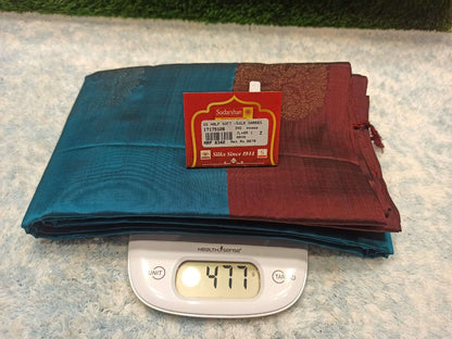 Two folded fabrics, one blue and one red, with a scale showing weight on a textured surface.