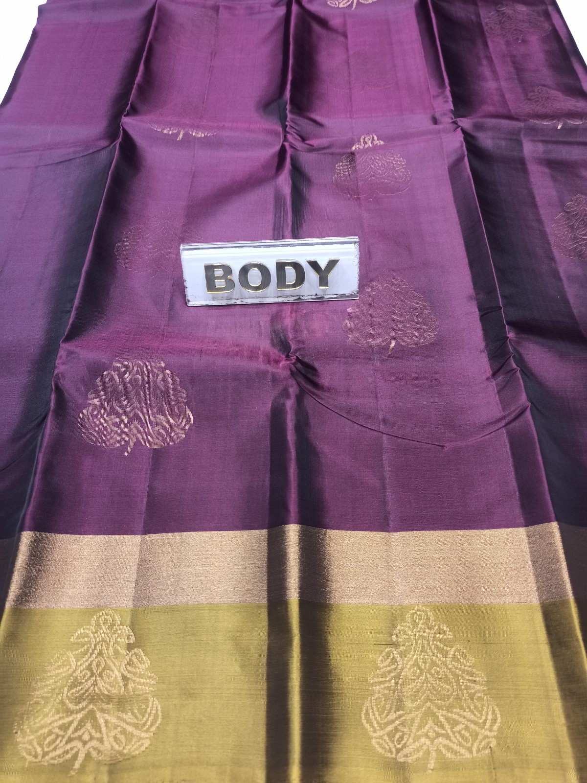 Purple and green fabric with gold patterns and a label reading 'BODY'.