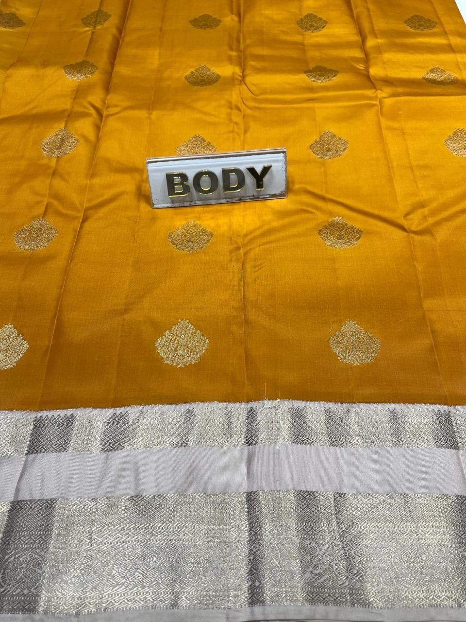 Yellow fabric with gold patterns and a label labeled 'BODY' on a gray fabric background.