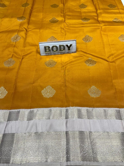 Yellow fabric with gold patterns and a label labeled 'BODY' on a gray fabric background.