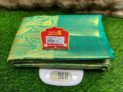 Green fabric with a label on a digital scale displaying weight, placed on green grass.