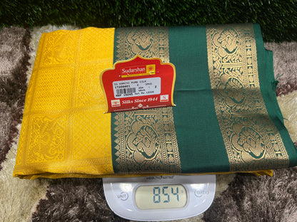 Green and yellow saree with a label on a digital weight scale