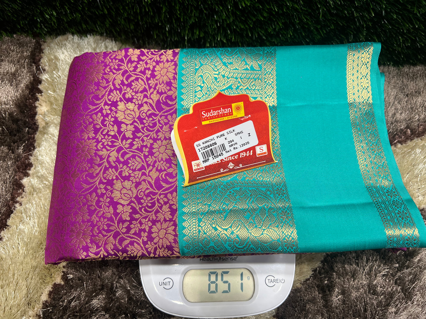 Teal and purple fabric with a label on a digital scale