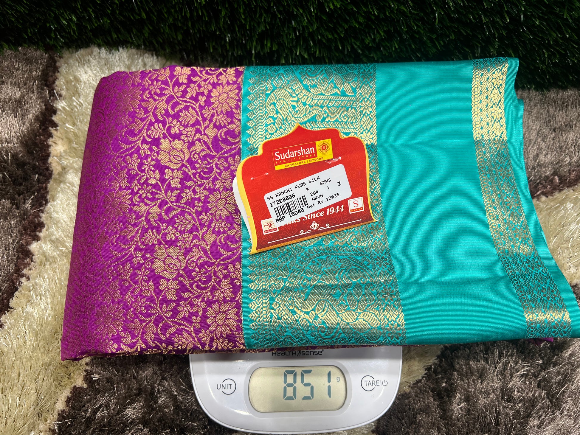 Teal and purple fabric with a label on a digital scale