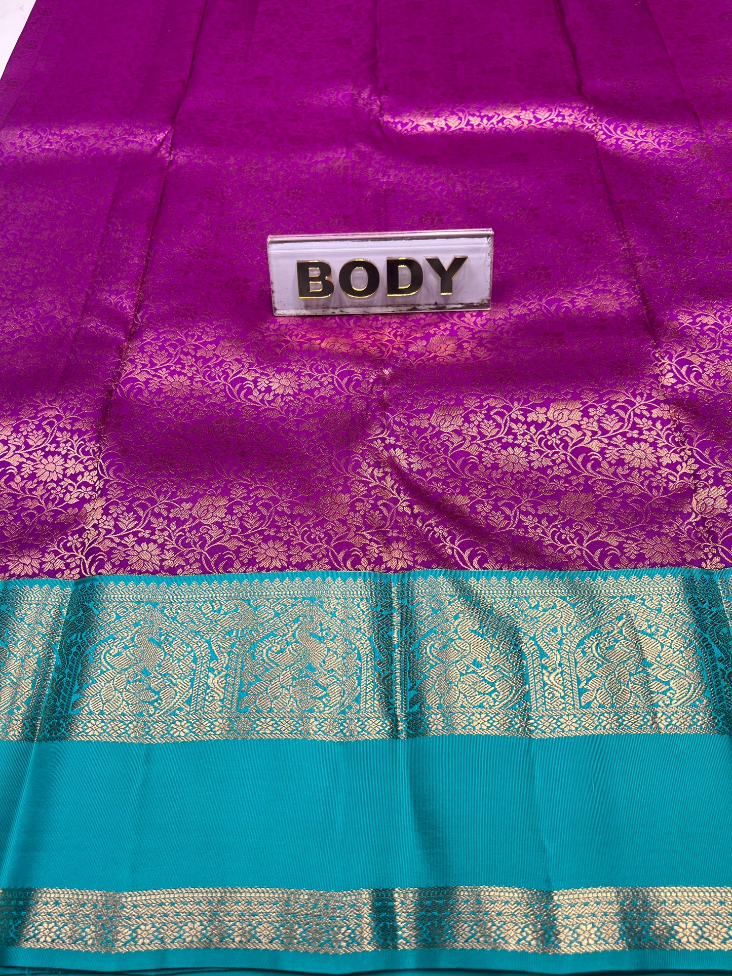 Purple and teal saree with a visible brand label.