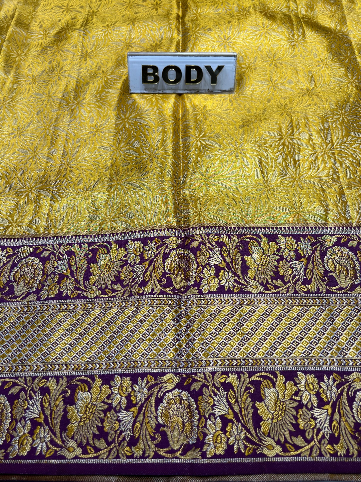Gold and purple fabric with floral patterns and a label labeled 'BODY'.