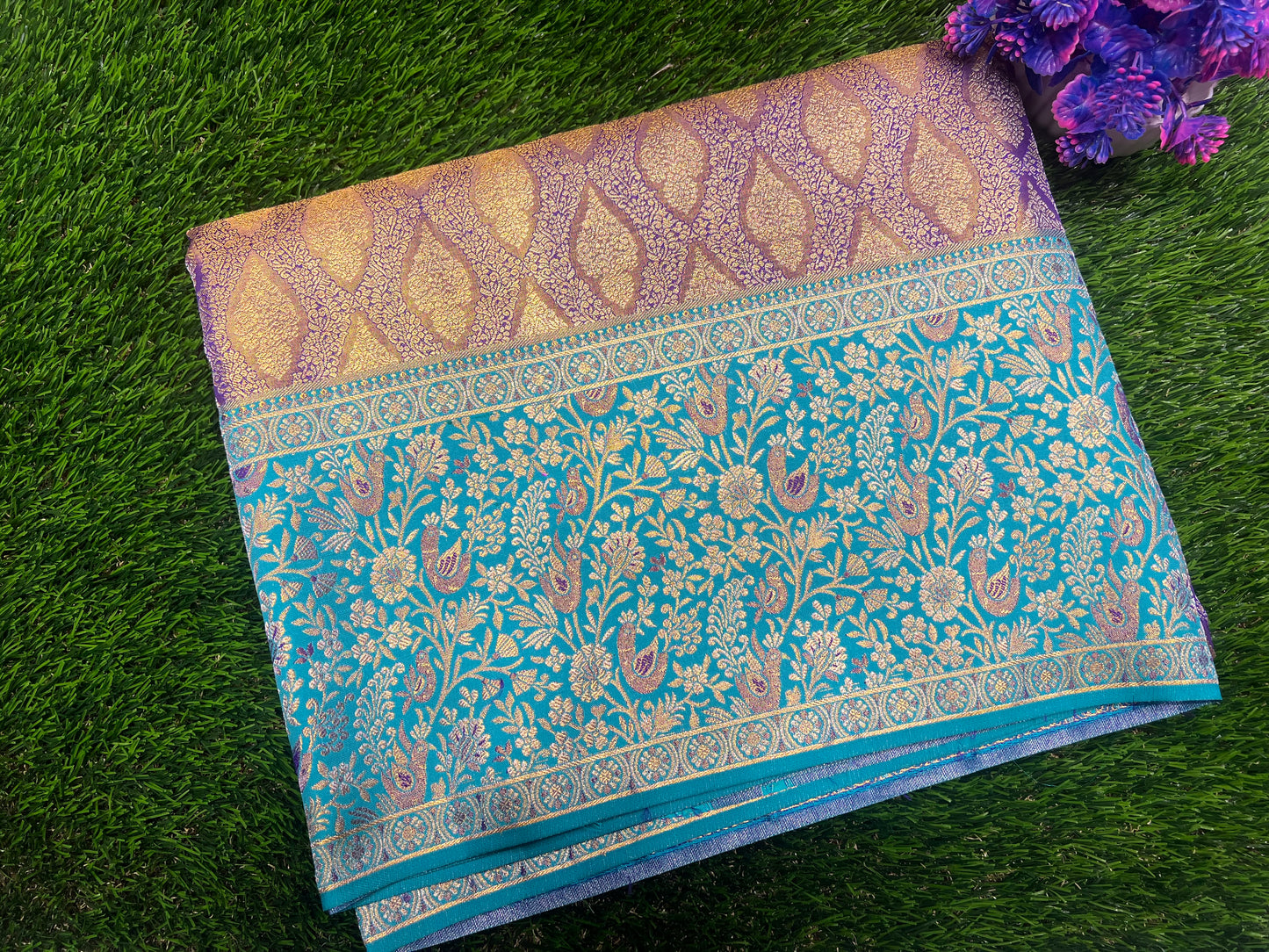 Blue and gold patterned fabric on a green grass background