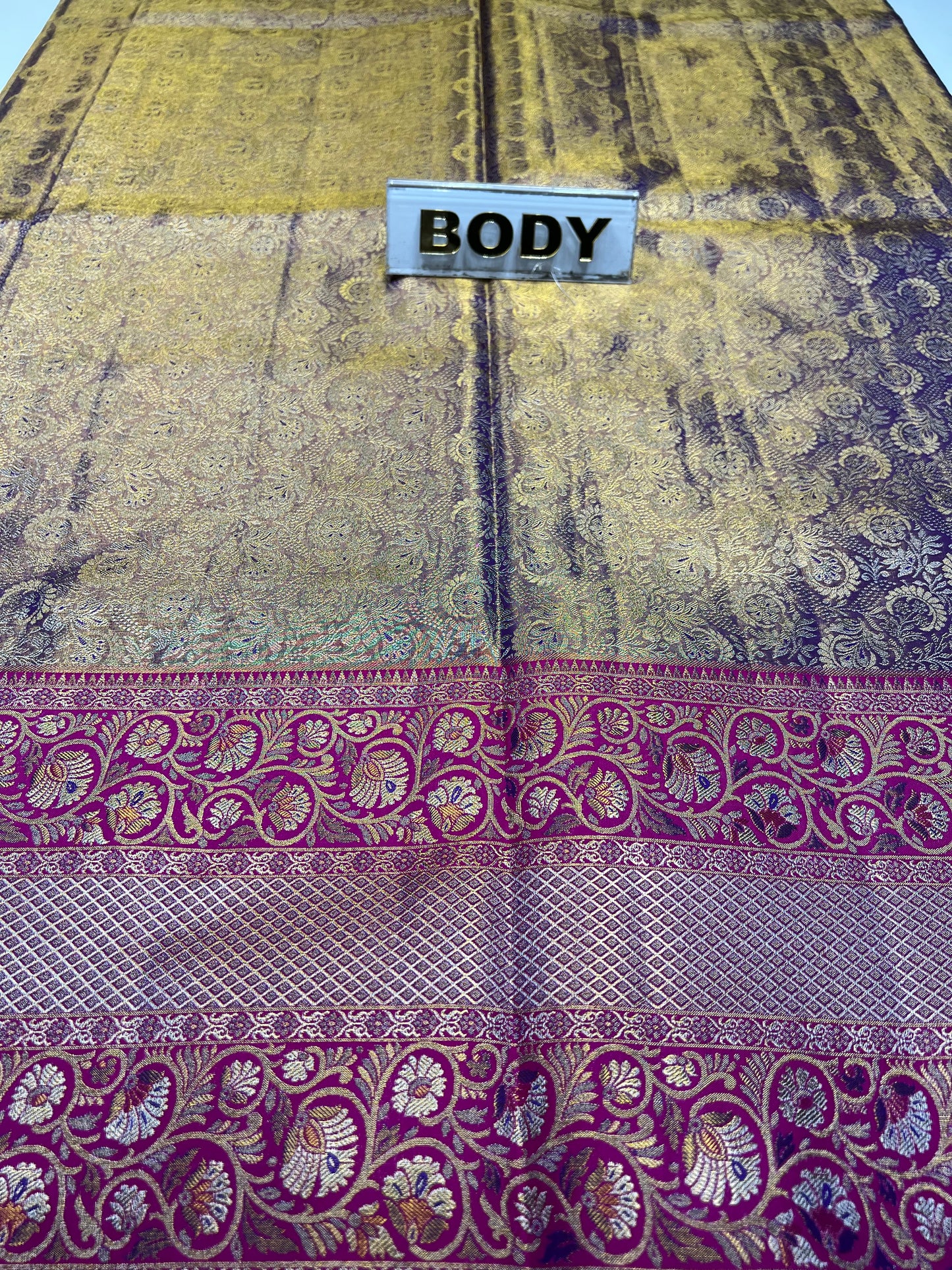 Decorative fabric with purple and gold patterns and a label labeled 'BODY'.