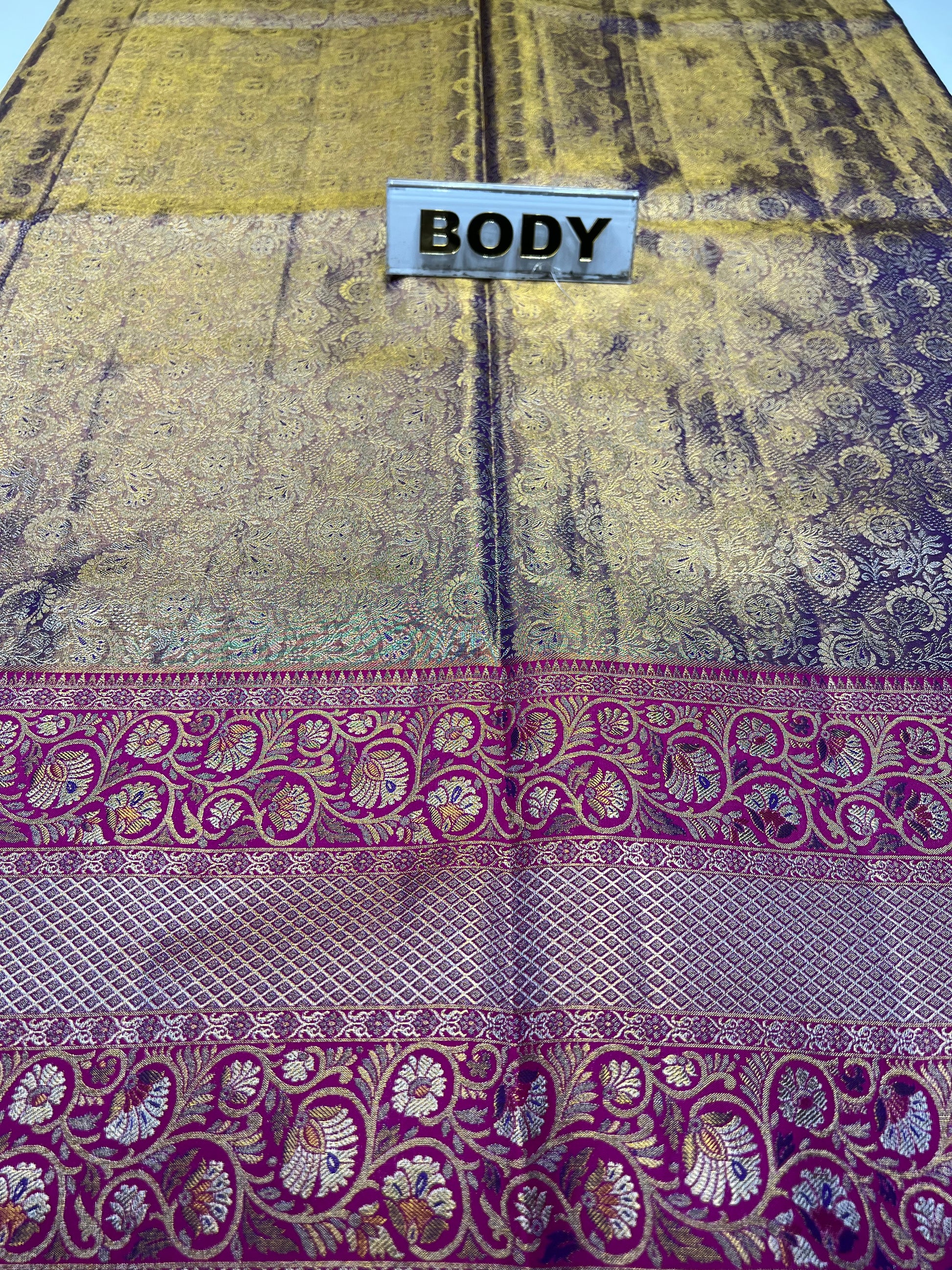Decorative fabric with purple and gold patterns and a label labeled 'BODY'.