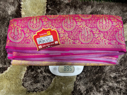 Pink and gold patterned fabric on a digital scale with a brand label.