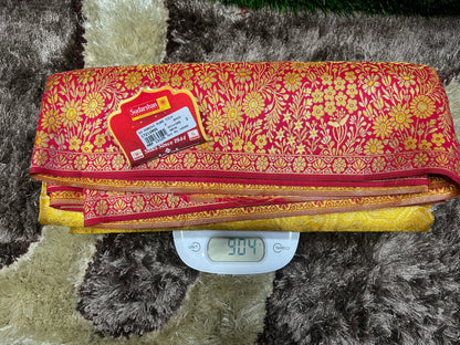 Red and gold patterned fabric on a digital scale with a label on a textured surface