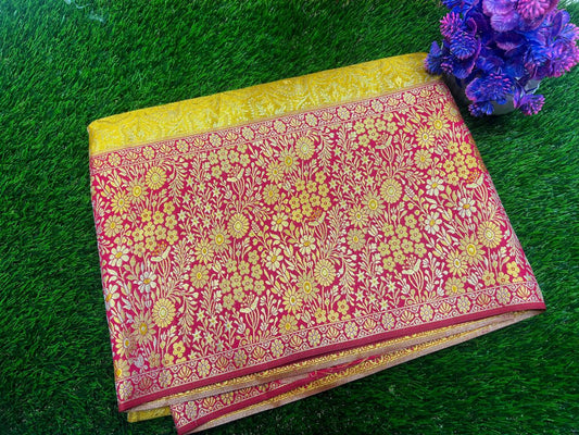 Red and yellow floral patterned fabric on a green grass background