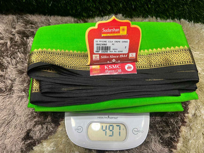 Green saree with a red label on a digital scale showing weight