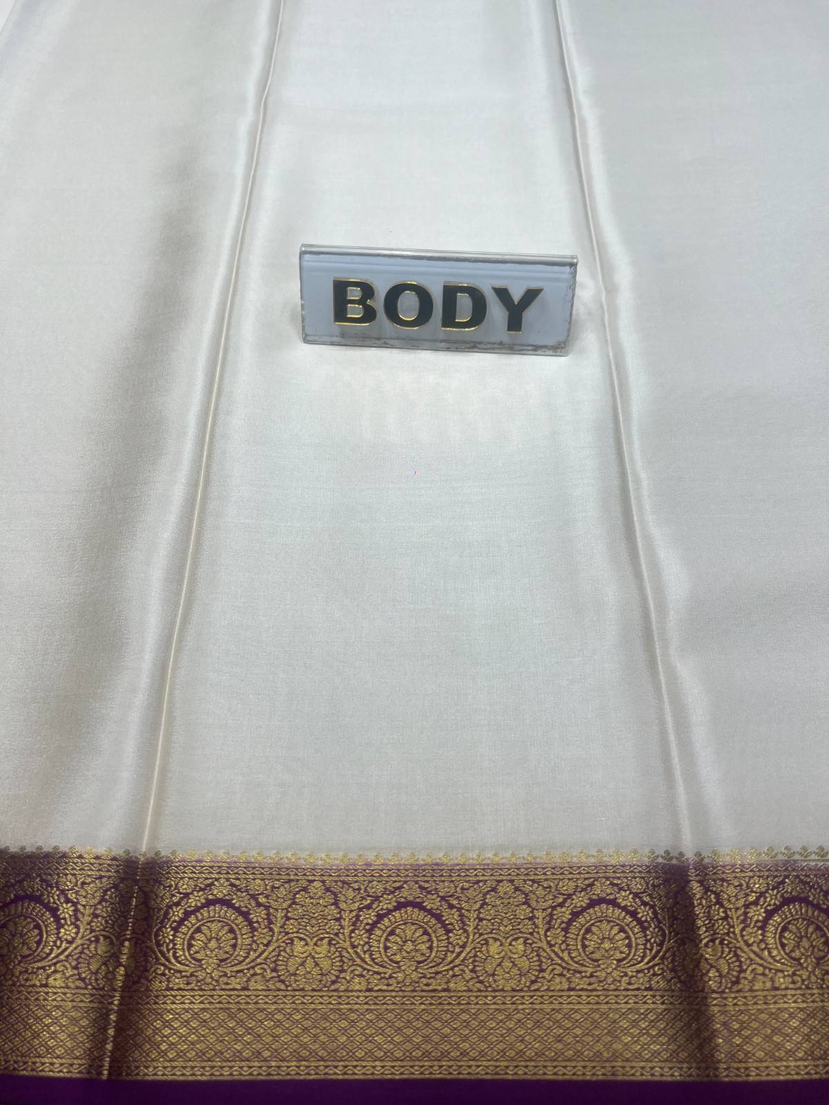 White fabric with gold border and 'BODY' label on a white background