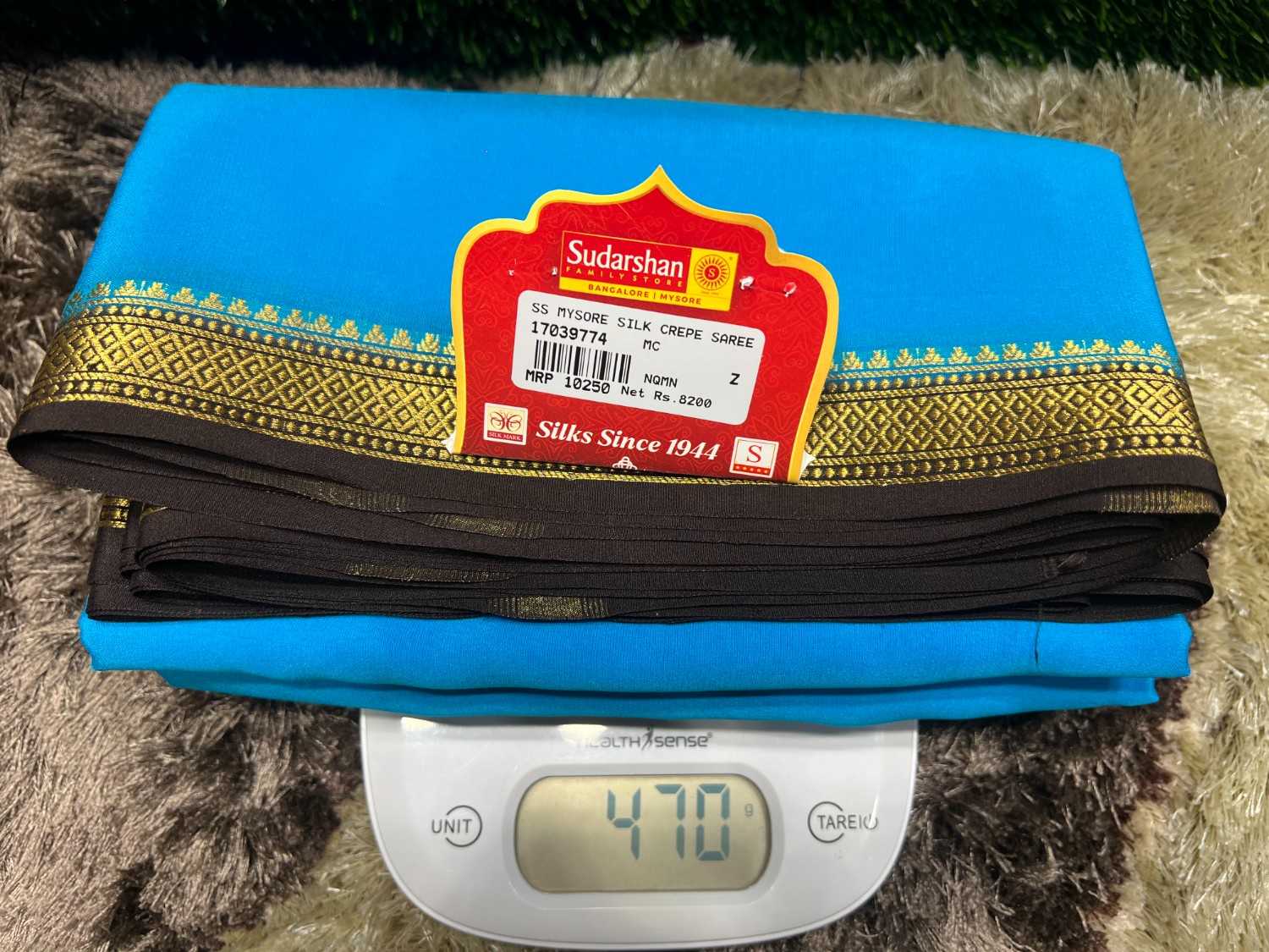 Blue saree with a brand label on a digital scale