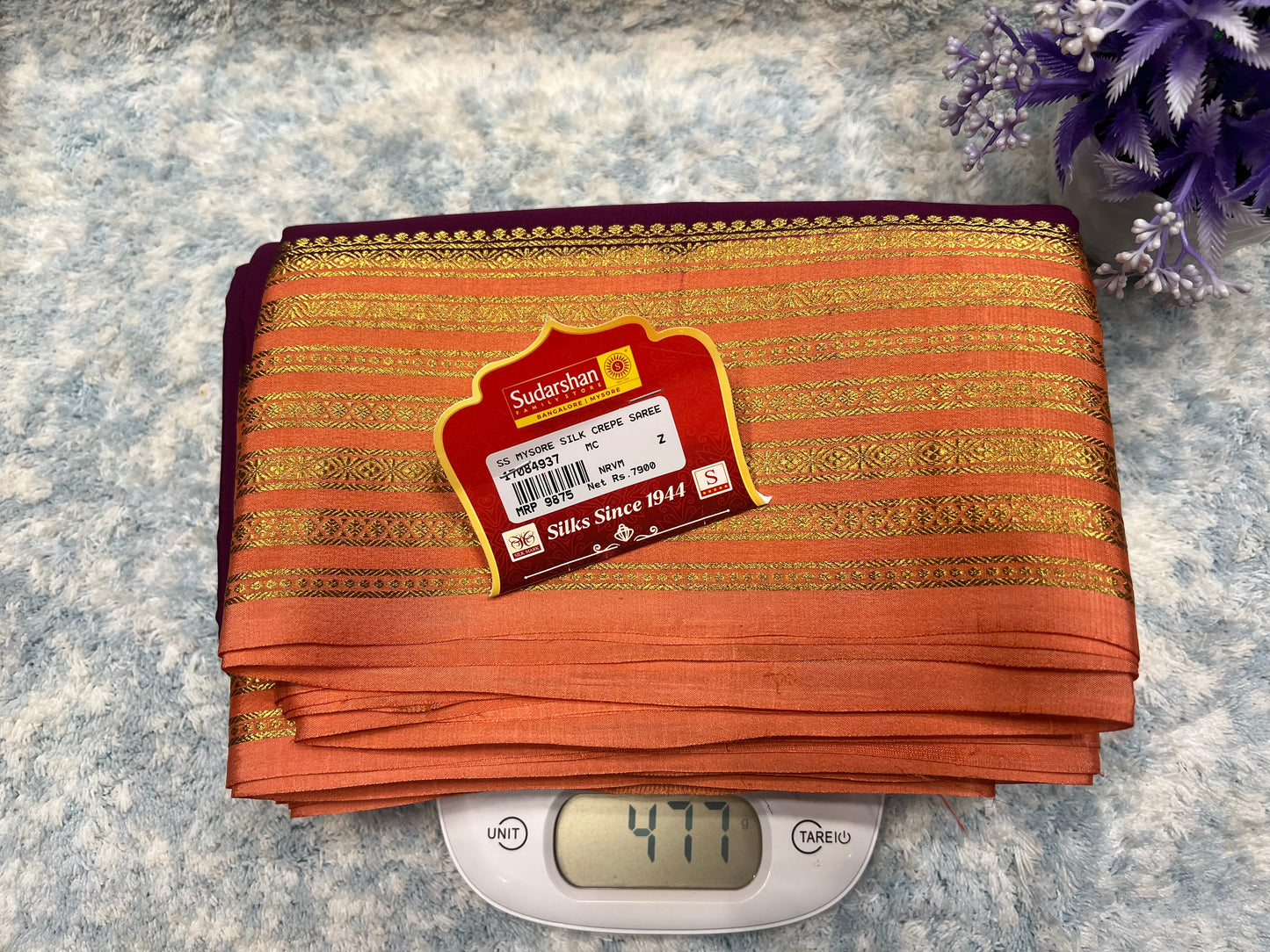 Packaged saree with a label on a digital scale