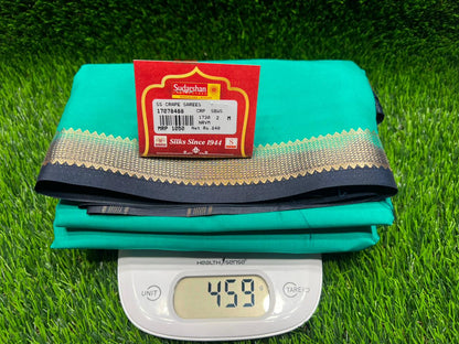 Teal fabric with a red label on a green grass background