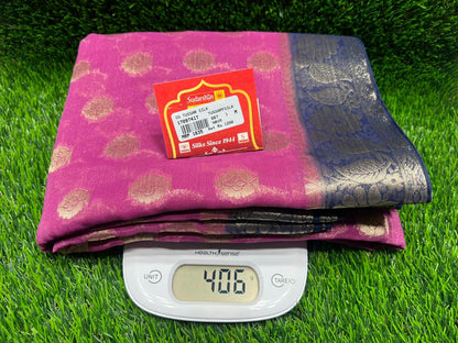 Pink fabric with a label on a green grass-like surface, weighed using a digital scale.