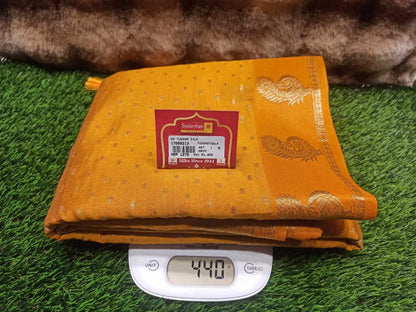 Yellow fabric with a brand label on a digital scale against a grassy background