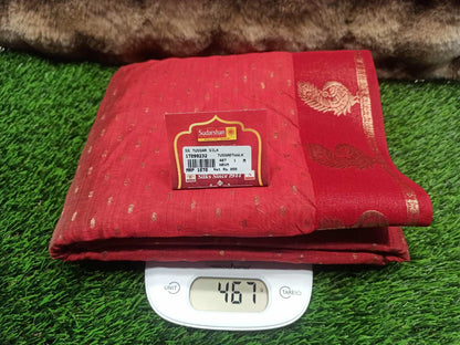 Red fabric with a label on a digital scale against a grass background