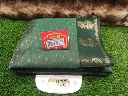 Green fabric with gold patterns on a digital scale, against a green grass-like background