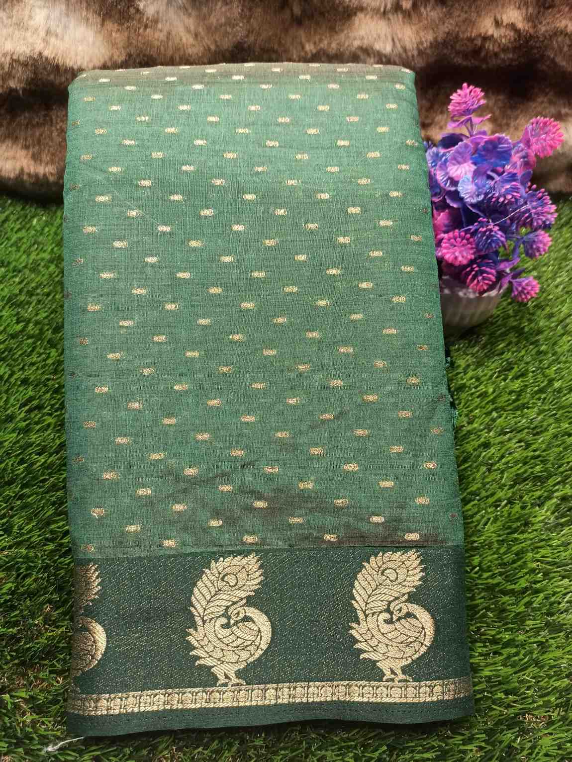 Green fabric with gold patterns on a grassy background