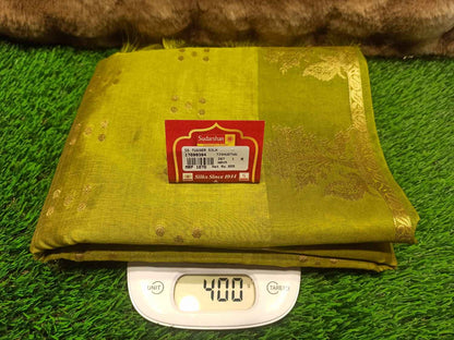 Green fabric with a label on a digital scale against a grassy background
