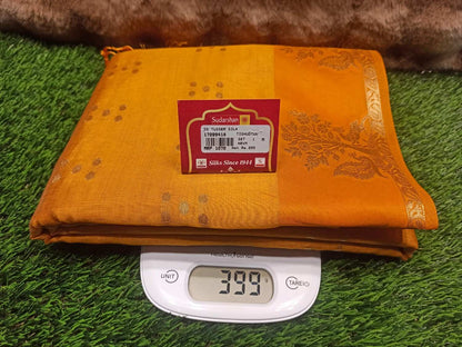 Orange fabric with a label on a digital scale on green grass