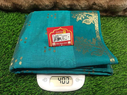 Teal fabric with a brand label on a digital scale against a grassy background
