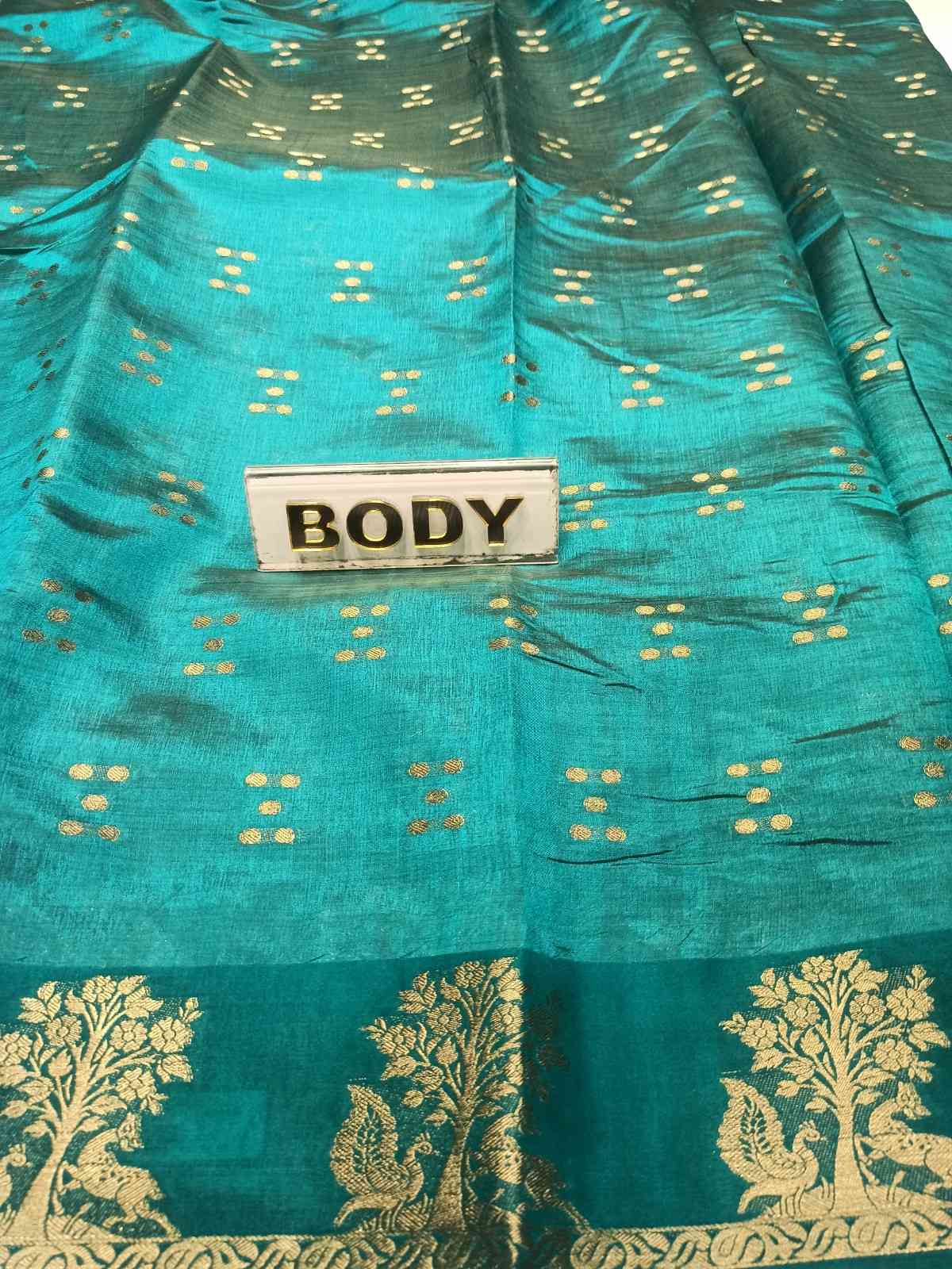 Teal fabric with gold patterns and a 'BODY' label.